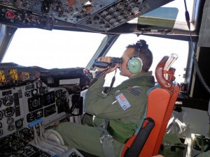 A Royal Australian Air Force pilot of an AP-3C Orion maritime patrol aircraft scans the surface of the sea near the west of Peninsula Malaysia in this handout picture by the Royal Australian Air Force, released via the Australian government's Department of Defence website on March 17, 2014.  REUTERS/Royal Australian Air Force/Handout via Reuters