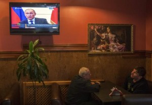 Local residents watch a TV broadcast of Russian President Vladimir Putin's news conference, in Kiev March 4, 2014.  CREDIT: REUTERS/ALEX KUZMIN