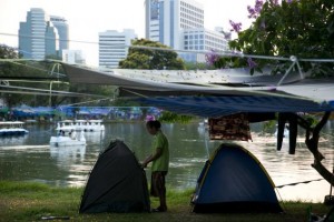 An anti-government protester adjusts her tent in Lumpini Park in downtown Bangkok April 6, 2014. Credit: Reuters/Darren Whiteside