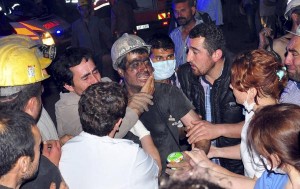 A rescued miner surrounded by relatives, medics and other miners cries after being rescued from a coal mine he was in trapped in Soma, a district in Turkey's western province of Manisa May 13, 2014. An explosion and fire in the coal mine in western Turkey killed at least four miners on Tuesday and may have trapped as many as 300 more, officials said. REUTERS/Ihlas/Yilmaz Saripinar