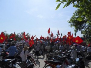 Workers wave Vietnamese national flags during an anti-China protest at a Chinese-owned shoe factory in Vietnam's northern Thai Binh province May 14, 2014. Thousands of Vietnamese set fire to foreign factories and rampaged in industrial zones in the south of the country in an angry reaction to Chinese oil drilling in a part of the South China Sea claimed by Vietnam, officials said on Wednesday. REUTERS/Stringer 