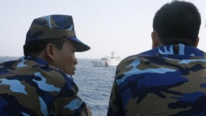 Officers of the Vietnamese Marine Guard talk as they monitor a Chinese coast guard vessel (top) on the South China Sea, about 210 km (130 miles) offshore of Vietnam May 15, 2014.   Photo Courtesy REUTERS/Nguyen Minh 