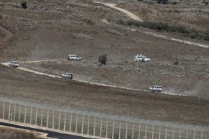 U.N. vehicles drive in Syria near the border fence with the Israeli-occupied Golan Heights