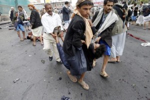 Shi'ite Houthi rebels carry a wounded man at the scene of a suicide attack in Sanaa October 9, 2014. REUTERS/Khaled Abdullah