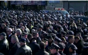 Many New York  police officers turned their backs and shunned the city's mayor as he delivered a eulogy at a crowded funeral for Rafael Ramos,  the slain New York cop.  (Photo grabbed from Reuters video)