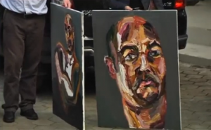 A lawyer for two Australian drug convicts on death row in Indonesia displays three self-portraits painted by one of the men facing a firing squad imminently.  (Photo grabbed from Reuters video/Courtesy Reuters)