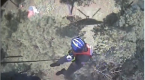 A rescue personnel sliding down an extended chord from helicopter towards fighter jet pilot.  Major Aaron Johnson, the pilot who ejected safely, was rescued and taken for a health evaluation. (Courtesy Reuters/Photo grabbed from Reuters video)