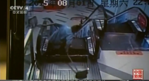 Within seconds of stepping over the escalator's top platform, a janitor, Zhang, slipped and his left foot was caught between a gap in the escalator's steps.  (Photo grabbed from CCTV video)