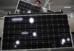 An employee carries a solar panel as he works at a production line at a solar company workshop in Yongkang, Zhejiang province February 23, 2012.  Courtesy REUTERS/Stringer/Files