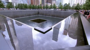 World Trade Center tower and reflection pool.  Solemn ceremony at the site of the World Trade Center marks the 14th anniversary of the September 11, 2001 attacks.  (Courtesy Reuters/Photo grabbed from Reuters video)