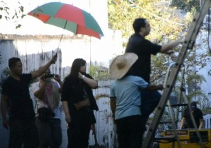 lottie with umbrella as son tries ladder