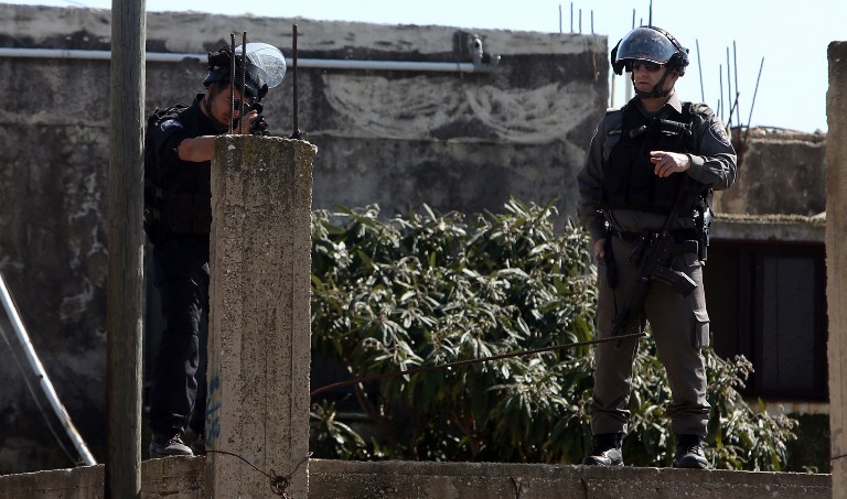 An Israeli soldier aims his weapon during clashes with Palestinian protesters following a demonstration against the expropriation of Palestinian land by Israel on February 12, 2016 in the village of Kfar Qaddum, near Nablus in the occupied West Bank. / AFP / JAAFAR ASHTIYEH