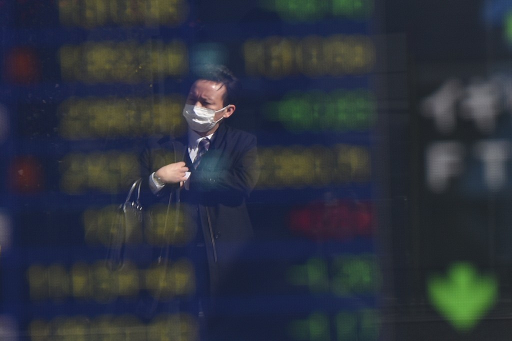 A businessman is reflected on an electric quotation board flashing share price indexes of the Tokyo Stock Exchange (TSE) in front of a securities company in Tokyo on February 9, 2016. Tokyo shares tumbled nearly five percent, extending a global sell-off as a stronger yen dented exporters and after oil prices tanked again on fears of a deepening economic slowdown.     AFP PHOTO/Toru YAMANAKA / AFP / TORU YAMANAKA