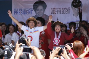 Philippine presidential candidate Miriam Santiago (centre R) and vice-presidential candidate Ferdinand Marcos Jr. (centre L), the son of late dictator Ferdinand Marcos, gesture to supporters onstage during a campaign rally in Batac town in Ilocos Norter province, north of Manila on February 9, 2016, at the start of the political campaign for the May 10 national elections. AFP PHOTO / AFP / STR