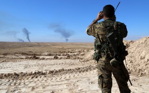 A member of a coalition force, which includes People's Protection Units (YPG) Women's Protection Units (YPJ), Sutoro militia, a pro-government Syriac Christian movement, and other forces, monitors the horizon in al-Hol in the Syrian Hasakeh province, some 650 kms northeast of Damascus, near the Iraqi border on November 2, 2015. (Photo from AFP/Delil Souleiman)