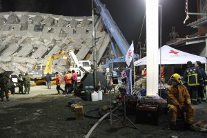 A fireman (R) rests during a rescue operation at the site of a collapsed building in the southern Taiwanese city of Tainan late on February 6, 2016 following a strong 6.4-magnitude earthquake. Relatives of residents trapped in a 16-storey apartment complex felled by a powerful earthquake in Taiwan that killed 14 people were praying for miracles Saturday as rescuers sought survivors, with more than 150 missing in the quake zone. (Photo by Anthony Wallace/AFP)