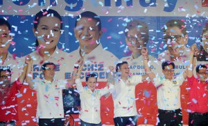 Philippine presidential candidate Grace Poe (3rd-L) and her running mate Senator Francis 'Chiz" Escudero (3rd-R) raise their arms with their senatorial slate as they launch their campaigns for the May national elections in Manila on February 9, 2016. A cliffhanger race to lead the Philippines began February 9, with the adopted daughter of a dead movie star and a tough-talking politician who claims to kill criminals among the top contenders. AFP PHOTO / Jay DIRECTO / AFP / JAY DIRECTO