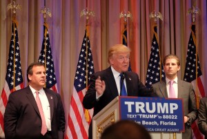 Republican presidential candidate Donald Trump speaks to the media during a campaign event in Palm Beach, Florida on March 1, 2016, following "Super Tuesday" poll results. At left is New Jersey Governor and former White House hopeful Chris Christie; at right is Trump's son Eric Trump.    White House hopeful Donald Trump said after a string of wins in the Super Tuesday primaries that he can bring the Republican party together to win the US presidency in November.  / AFP / Gaston De Cardenas