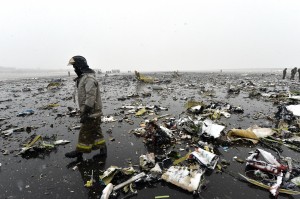 Russian emergency rescuer walks through wreckage of the flydubai passenger jet which crashed, killing all 62 people on board as it tried to land in bad weather in the city of Rostov-on-Don on March 19, 2016. The plane, which came from Dubai, was making its second attempt to land when it missed the runway, erupting in a huge fireball as it crashed, leaving debris scattered across a wide area. The ministry said more than 700 rescuers and 100 vehicles were combing the area in driving wind and snow where the wreckage was strewn, with investigators confirming one of the plane's black boxes had been retrieved. / AFP / -