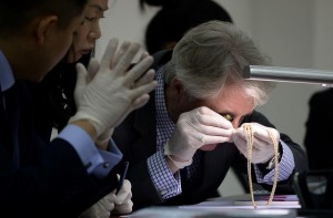 Christie's and Sotheby's auction house appraiser David Warren (R) examines diamond jewellery seized by the Philippine government from former first lady Imelda Marcos, at the Central Bank headquarters in Manila on November 24, 2015. Philippine authorities on November 24 showcased a dazzling collection of jewels seized from the family of the late dictator Ferdinand Marcos appraised in preparation for a possible auction. The long-hidden collection, seized in three batches after Marcos was overthrown in 1986, also provides a stark look at how the Marcos family enriched itself while the nation sank deeper into poverty.     AFP PHOTO / NOEL CELIS / AFP / NOEL CELIS