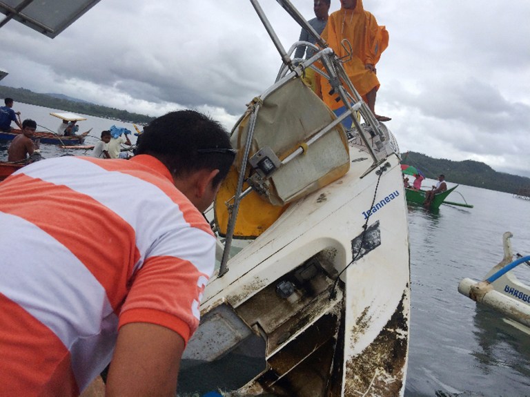 This recent undated handout photo released by Barobo police station on March 2, 2016 shows people standing on a partially-capsized boat believed to be owned by German national Manfred Fritz Bajorat whose body was found inside, after residents found the yatch drifting off the coast of Barobo, on the southern Philippine island of Mindanao. The German man whose mummified body was found on a yacht adrift off the southern Philippines had died of a heart attack about a week earlier, according to an autopsy report released on March 2.       AFP PHOTO/Barobo Police       --EDITORS NOTE---RESTRICTED TO EDITORIAL USE - MANDATORY CREDIT "AFP PHOTO / BAROBO POLICE" - NO MARKETING NO ADVERTISING CAMPAIGNS - DISTRIBUTED AS A SERVICE TO CLIENTS / AFP / BAROBO POLICE / BAROBO POLICE