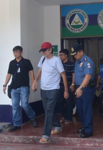 Retired Italian priest Rolando Del Torchio (C), escorted by police, leaves a military hosipital in Zamboanga City in southern island of Mindanao on April 9, 2016, a day after his release.  A retired Italian priest held hostage for six months by Islamic militants in the southern Philippines left a military hospital April 9, looking frail a day after his release, officials and witnesses said.. / AFP PHOTO / STR