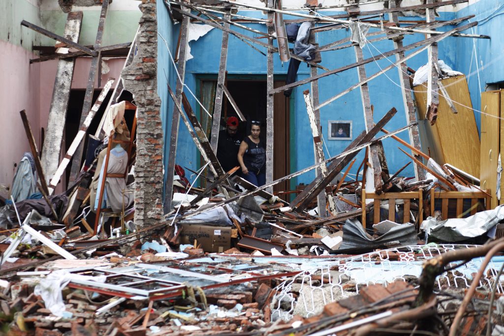 Residents look at the remains of their house hit by a tornado in Dolores, Uruguay on April 16, 2016. At least four people were killed and seven severely injured Friday by a tornado 265 km west of Montevideo, official sources reported. / AFP PHOTO / Nicolas Garcia