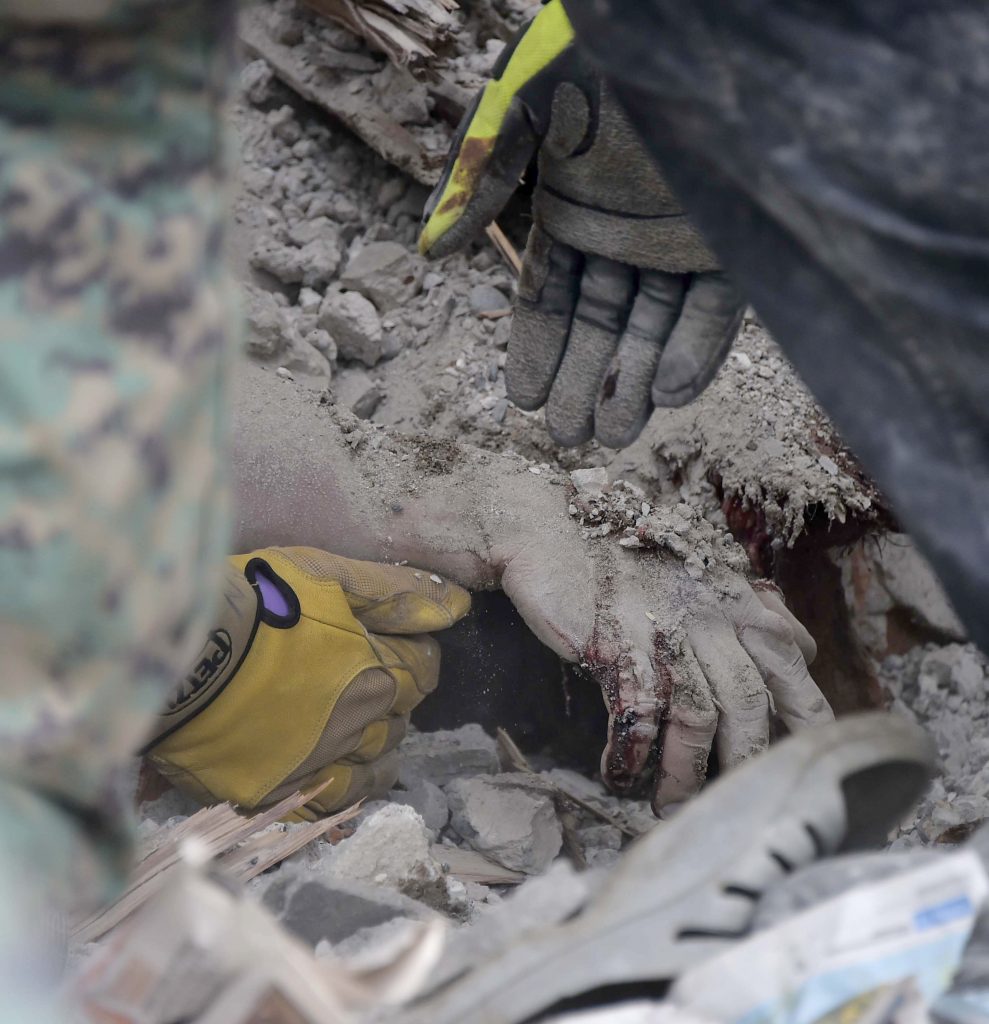 A human hand is seen amid the rubble after a 7.8-magnitude quake in Pedernales, Ecuador on April 17, 2016. At least 233 people have been killed in the 7.8-magnitude earthquake that struck Ecuador's Pacific coast, President Rafael Correa said Sunday. RODRIGO BUENDIA / AFP