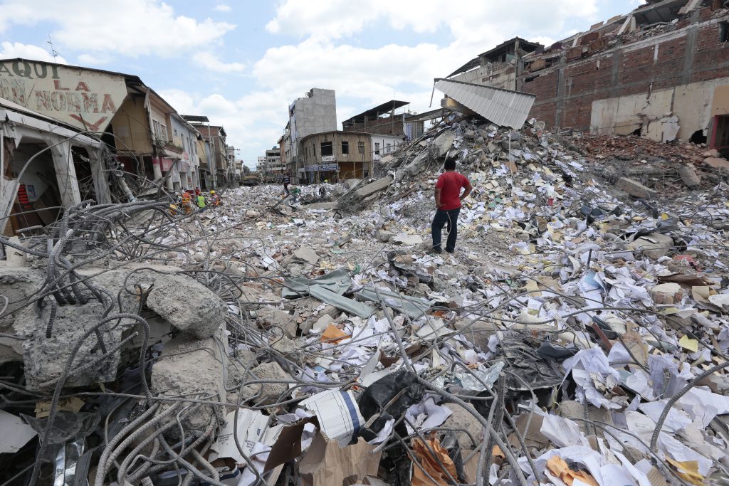 A man stares at the rubble in Portoviejo, Ecuador on April 20, 2016. The death toll from Ecuador's earthquake was set to rise sharply after authorities warned that 1,700 people were still missing and anger gripped families of victims trapped in the rubble. A 6.1-magnitude earthquake struck off the coast of Ecuador Wednesday, sowing new panic four days after a more powerful quake killed more than 525 people, with hundreds still missing. / AFP PHOTO / Juan Cevallos