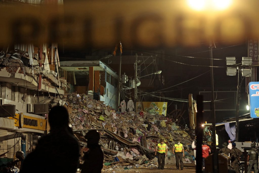 Firefighters wear white colored suits to care for the biological risk arising from the putrefaction of the corpses during the clean-up operations and rescue  of the earthquake victims in Manta on April 20, 2016. The death toll from Ecuador's earthquake was set to rise sharply after authorities warned that 1,700 people were still missing and anger gripped families of victims trapped in the rubble. A 6.1-magnitude earthquake struck off the coast of Ecuador Wednesday, sowing new panic four days after a more powerful quake killed more than 525 people, with hundreds still missing. / AFP PHOTO / Juan Cevallos