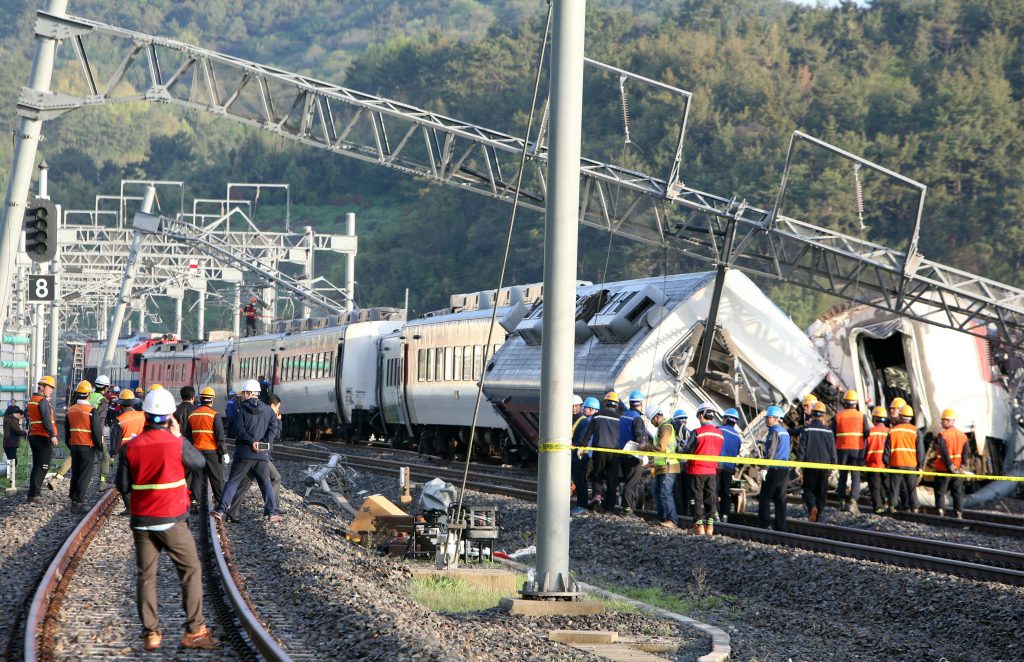 South Korea railway workers struggle to put a derailed passenger train back on track in the southern port city of Yeosu on April 22, 2016. The train derailed early on April 22, leaving the locomotive driver dead and eight passengers injured.   / AFP PHOTO / YONHAP / YONHAP / REPUBLIC OF KOREA OUT  NO ARCHIVES  RESTRICTED TO SUBSCRIPTION USE