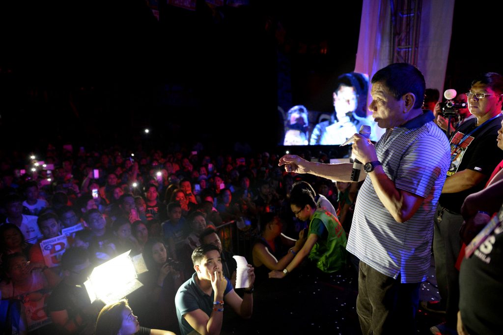 Philippine presidential front-runner candidate Rodrigo Duterte (C) states his political platform in front of his supporters during a campaign in Manila on April 23, 2016. Trash-talking Philippine presidential favourite Duterte has warned he is prepared to cut diplomatic ties with the United States and Australia after their envoys criticised his comments about the jailhouse rape of a missionary. / AFP PHOTO / NOEL CELIS