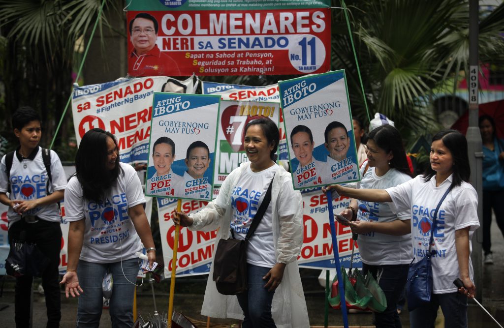 This picture taken on April 24, 2016 shows volunteers in Hong Kong holding placards to campaign for the upcoming 2016 Philippine election. Twerking, selfie-taking, picnicking and performing impromptu dance routines -- Hong Kong's 180,000-strong community of Filipino workers fill the city's public spaces on Sundays, their day off, to relax and party. But for the past few weeks the colourful gatherings have turned political, as the Philippines heads towards an election in which its migrant workers could swing a tight race. / AFP PHOTO / ISAAC LAWRENCE / TO GO WITH AFP STORY BY Kate BARTLETT