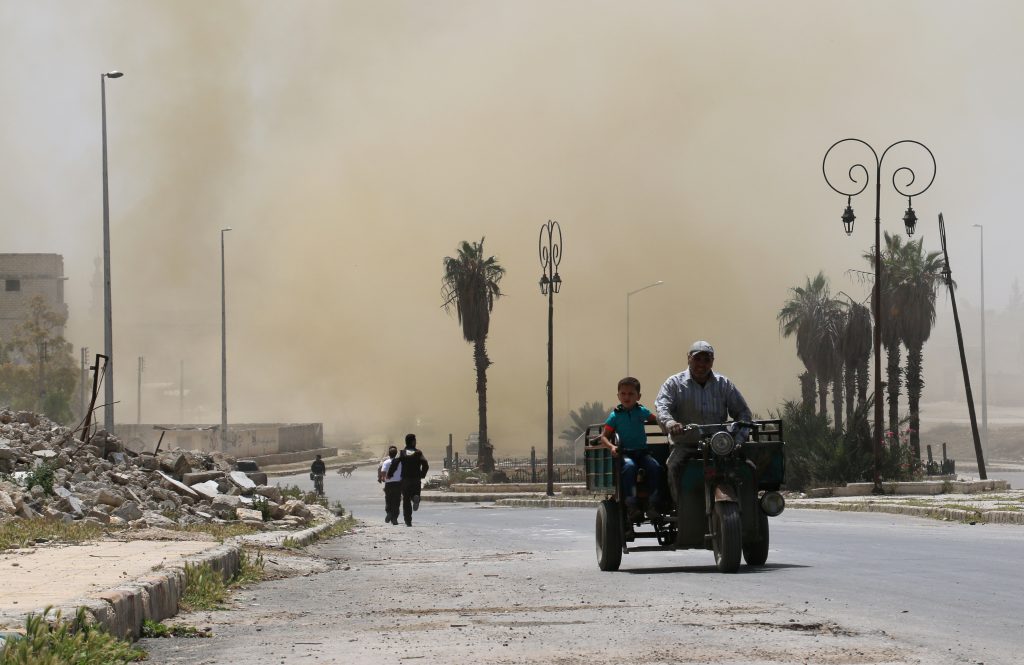 Syrians evacuate the area following an air strike on the rebel-held eastern Bab al-Nayrab neighbourhood of the northern Syrian city of Aleppo on April 26, 2016.  Air strikes on rebel-held areas of Syria's second city Aleppo and a town to its west killed at least over a dozen people emergency workers said. / AFP PHOTO / AMEER ALHALBI