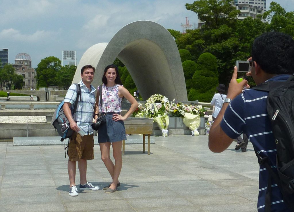 TO GO WITH Japan-US-nuclear-weapons-WWII,ADVANCER by Shingo Ito Foreign tourists pose for souvenir pictures in front of the altar for victims of the 1945 atomic bombing at Hiroshima's Peace Memorial Park in western Japan on August 1, 2010. Sixty-five years after a mushroom cloud rose over charred Hiroshima, the United States will for the first time send an envoy on August 6, 2010 to commemorate the bombing that rang in the nuclear age.    AFP PHOTO / Shingo ITO / AFP PHOTO / SHINGO ITO