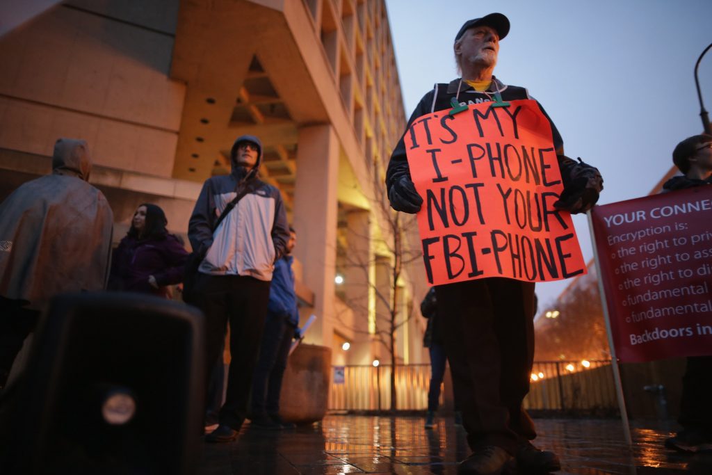 WASHINGTON, DC - FEBRUARY 23: Organized by Fight for the Future, about a dozen protestors demonstrate outside the Federal Bureau of Investigation's J. Edgar Hoover headquarters in support of Apple and against a move by the federal government to force the computer company to create a "backdoor" to the iPhone February 23, 2016 in Washington, DC. Last week a federal judge ordered Apple to write software that would allow law enforcement agencies investigating the December 2, 2015 terrorist attack in San Bernardino, California, to hack into one of the attacker's iPhone. Apple is fighting the order, saying it would create a way for hackers, foreign governments, and other nefarious groups to invade its customers' privacy. Chip Somodevilla/Getty Images/AFP