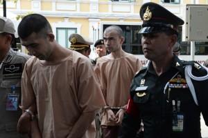 (File photo) Suspects in the Erawan shrine bombing in Bangkok in August 2015, identified by the ruling junta as Adem Karadag (C) and Yusufu Mieraili (front L), are escorted by police at a military court in Bangkok on April 20, 2016.  The two men suspected of carrying out the deadly bombing at a Bangkok shrine last year plead not guilty over the unprecedented attack on the heart of the Thai capital. Yusufu Mieraili and Adem Karadag, also known as Bilal Mohammed, arrived at the military court where hearings were set to continue. / AFP PHOTO / LILLIAN SUWANRUMPHA