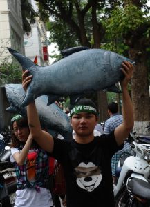 Vietnamese protesters demonstrate against Taiwanese conglomerate Formosa during a rally in downtown Hanoi on May 1, 2016.  Around a thousand people poured into Vietnam's two major cities Hanoi and Ho Chi Minh City to protest against Taiwan's Formosa, which operates a steel plant which they claim is causing mass fish kills due to pollution in Vietnam's central coast. / AFP PHOTO / HOANG DINH NAM