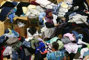 A woman picks through donated clothing and goods at a makeshift evacuee center in Lac la Biche, Alberta on May 5, 2016, after fleeing forest fires north of Fort McMurray. Raging wildfires pressed in on the Canadian oil city of Fort McMurray Thursday after more than 80,000 people were forced to flee, abandoning fire-gutted neighborhoods in a chaotic evacuation. No casualties have been reported from the monster blaze, which swept across Alberta's oil sands region driven by strong winds and hot, dry weather.  / AFP PHOTO / Cole Burston