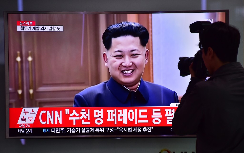 A photographer takes a picture of a television screen showing file footage of North Korean leader Kim Jong-Un, at a railway station in Seoul on May 6, 2016. North Korea raised the curtain on May 6 on its biggest political show for a generation, aimed at cementing the absolute rule of leader Kim Jong-Un and shadowed by the possibility of an imminent nuclear test. / AFP PHOTO / JUNG YEON-JE