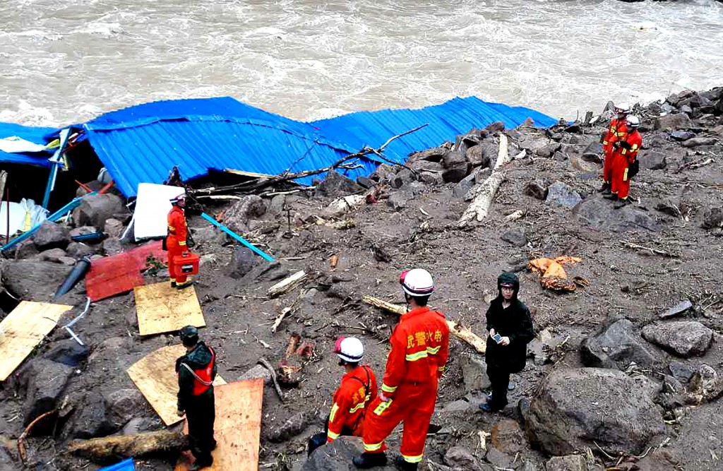 Rescuers search for survivors in the wreckage of a shelter after it was hit by a landslide in Taining County, in China's eastern Fujian province on May 8, 2016.  Thirty-four construction workers are missing after the landslide buried the temporary shelter.  / AFP PHOTO / STR / China OUT