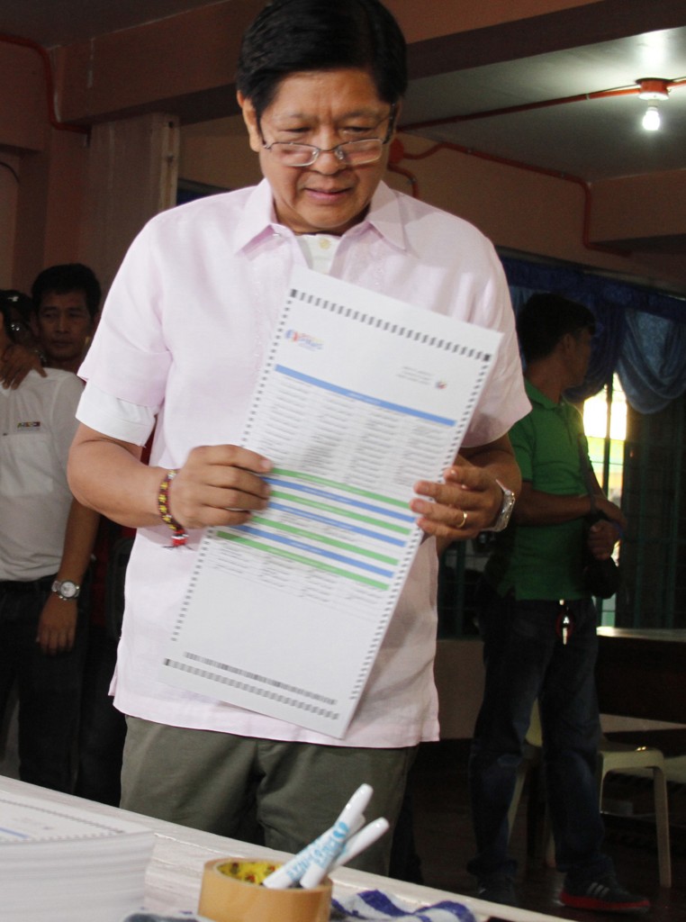 Ferdinand Marcos Jnr. (C), vice-presidential candidate and son of the late dictator Ferdinand Marcos, casts his ballot in the presidential election at a polling station in Batac, Ilocos norte province, north of Manila on May 9, 2016. The Philippines on May 9 launched elections to elect a new president with anti-establishment firebrand Rodrigo Duterte the shock favourite after an incendiary campaign full of profanity-laced threats to kill criminals. / AFP PHOTO / STR