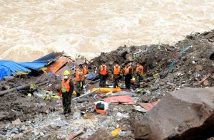 Rescuers stand in silent tribute for people killed during a landslide in Taining County, in China's eastern Fujian province on May 9, 2016. The landslide in southeastern China has killed 22 and left 17 still missing, state media said on May 9, after it engulfed workers at construction site. / AFP PHOTO / STR / China OUT