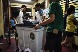 Polling officers carry a vote counting machine after polls closed in the presidential election in Manila on May 9, 2016./ AFP PHOTO / MOHD RASFAN