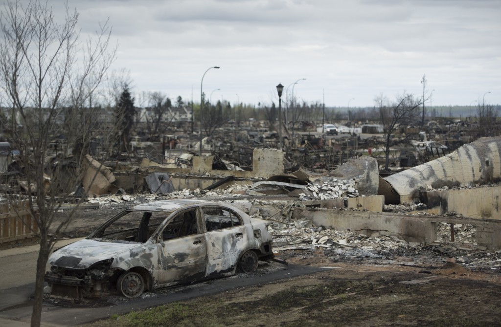 A burnt out pick up truck is seen in the driveway of a burnt down home in the Beacon Hill neighbourhood in Fort McMurray, Alberta, Monday, May 9, 2016. Authorities battling a forest fire in Canada looked to Mother Nature for more help May 9, as cooling temperatures and rain slowed the spread of the blaze that had forced the evacuation of an entire city.  / AFP PHOTO / POOL / JONATHAN HAYWARD