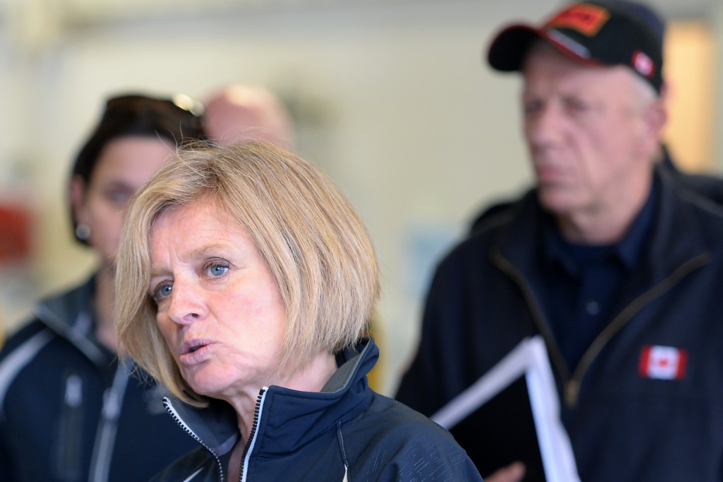 Alberta Premier Rachel Notley (L) speaks at the Fort McMurray fire department as fire chief Darby Allen looks on in Fort McMurray, Monday, May 9, 2016.  Fort McMurray is still 90-percent intact despite a week of damage from the wildfires devastating Canada's oil sands region, Alberta's premier said after touring the deserted city on Monday. Firefighters warned however that the tens of thousands of residents evacuated from the western oil city would not be able to return for at least two weeks.  / AFP PHOTO / POOL / Jonatan Hayward