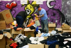 Fire evacuees sift through donated clothing at an Emergency Relief Centre in Edmonton, Alberta on May 10, 2016. Oil companies forced to halt production when Fort McMurray was hit by raging forest fires should resume production "in the coming days and short weeks ahead," Alberta Premier Rachel Notley said May 10th. / AFP PHOTO / Cole Burston