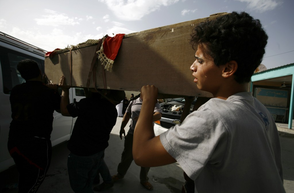 An Iraqi youth mourns as he carries the coffin of a victim of a car bombing in Baghdad's Shiite area of Sadr City during a funeral for people who died in the attack in the holy city of Najaf on May 11, 2016. The car bombing claimed by the Islamic State jihadist group killed at least 64 people at a market in a Shiite area of Baghdad, in the single deadliest attack this year in the capital. / AFP PHOTO / HAIDAR HAMDANI