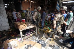 Iraqi security forces gather at the site of a suicide bombing in the Shaab area in northern Baghdad on May 17, 2016. Interior ministry spokesman Saad Maan said the attack was carried out by a female suicide bomber, while a police colonel said a roadside bombing was followed by the suicide attack. / AFP PHOTO / AHMAD AL-RUBAYE