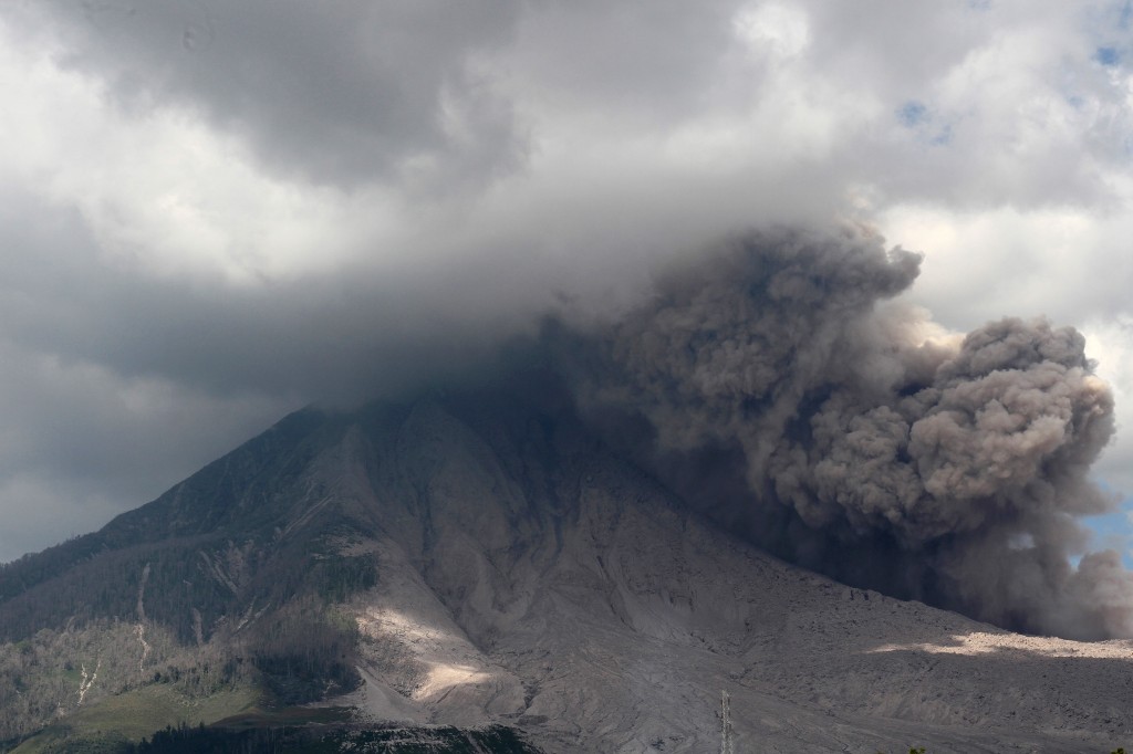 This picture taken on January 10, 2016 shows Mount Sinabung spewing volcanic ash in Karo. Sinabung is one of 129 active volcanoes in Indonesia, which sits on the Pacific Ring of Fire, a belt of seismic activity running around the basin of the Pacific Ocean. AFP PHOTO / JANUAR / AFP PHOTO / JANUAR